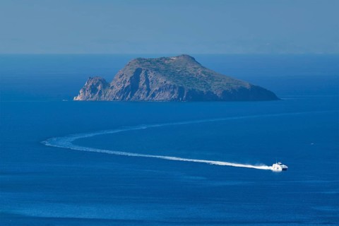 Speeding speed boat catamaran ferry vessel in Aegean sea near Milos island on summer day in Greece