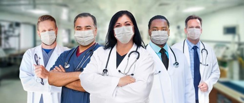 Variety of medical healthcare workers wearing medical face masks amidst the coronavirus pandemic within hospital