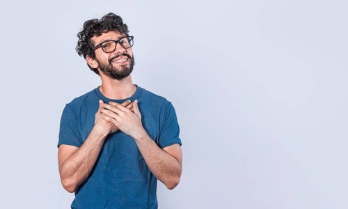 Attractive friendly and positive looking young man with a charming sincere smile feeling grateful