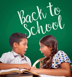 Back to school written on chalk board behind hispanic boy and girl having fun studying together