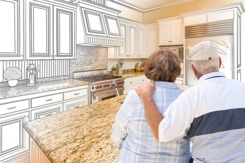 Senior couple looking over custom kitchen design drawing and photo combination