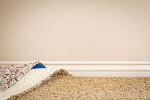 Pulled back carpet and underlay in room of house