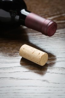 Wine bottle and cork on a reflective wood surface abstract