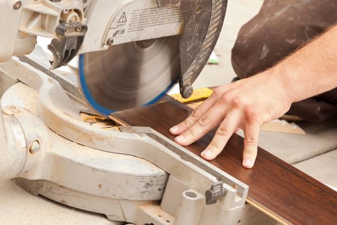 Contractor using circular saw cutting of new laminate flooring renovation