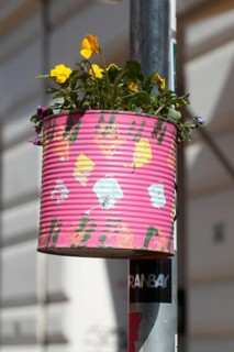 Colourfully painted tin can as a flower pot