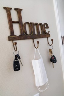 Home key hanger rack next to door with keys and medical face mask during coronavirus pandemic