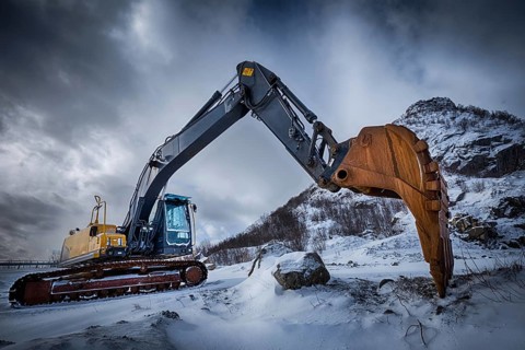 Old excavator with excavator bucket in winter