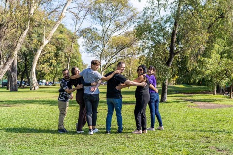 Multi ethnic family group walking arm in arm in a park