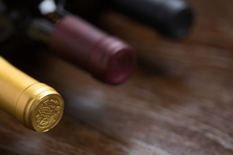Various wine bottles on a reflective wood surface abstract