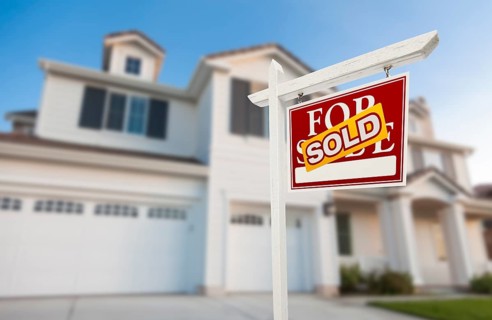 Sold home for sale real estate sign in front of beautiful new house