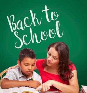 Back to school written on chalk board behind hispanic young boy and famale adult studying