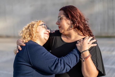 Couple of lesbian women hugging in a park looking at each other