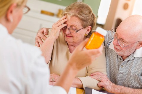Doctor or nurse explaining prescription medicine to senior adult couple