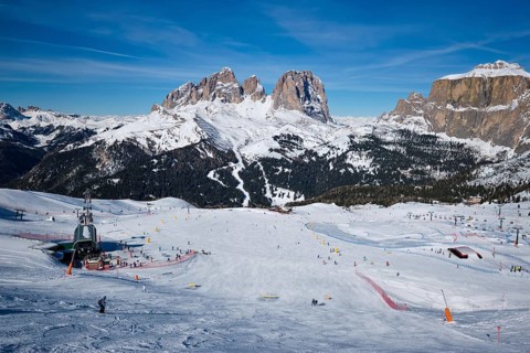 View of a ski resort piste with people skiing in Dolomites in Italy