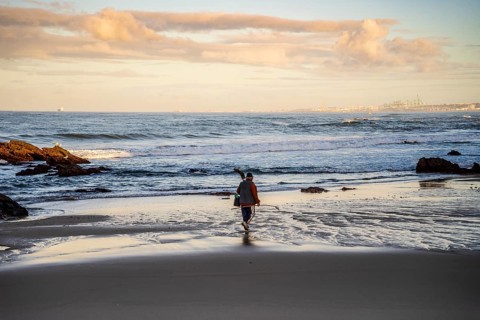 A fisherman walking on Samoqueira Beach