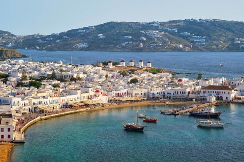 View of Mykonos town Greek tourist holiday vacation destination with famous windmills