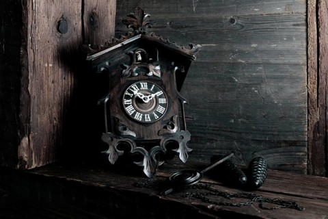 Antique Black Forest cuckoo clock on wooden background