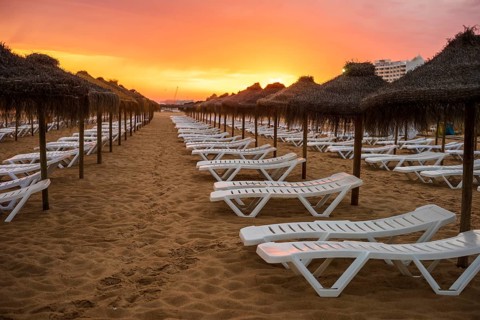 Beautiful colorful sunset over sun beds and umbrellas in Vilamoura