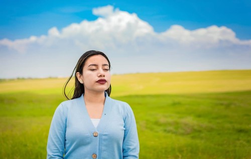 A young girl breathing fresh air in the field