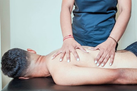 Man having chiropractic back adjustment. physiotherapist curing patient's spine problems