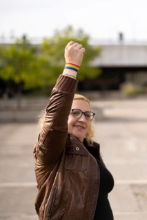 Young blonde woman showing lgbt wristband