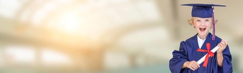 Cute young caucasian boy wearing graduation cap and gown against campus school background banner