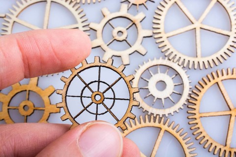 Hand holding gear wheels as the concept of mechanism