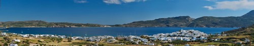 Panorama of Plaka village with traditional Greek church white painted Greek houses and ocean coast. Milos island
