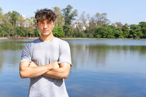 Portrait of confident young blond man with crossed arms looking at camera