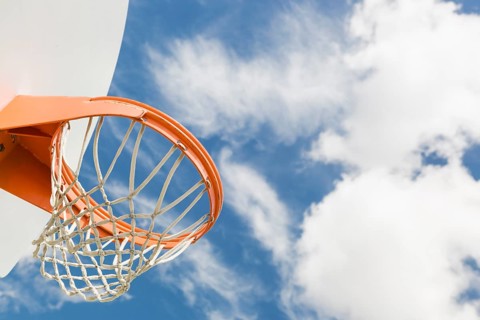 Abstract of community basketball hoop and net against blue sky