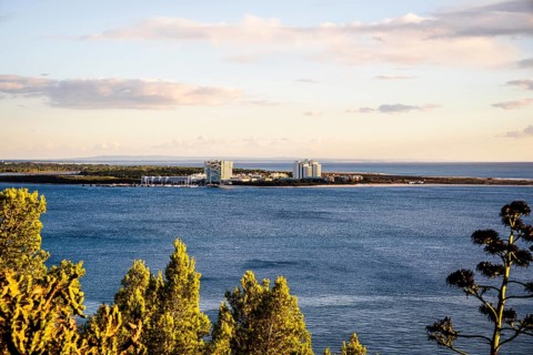 Cityscape of Troia by sunset with Atlantic ocean and trees in the foreground