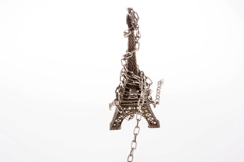 Little model Eiffel Tower in chains on a white background