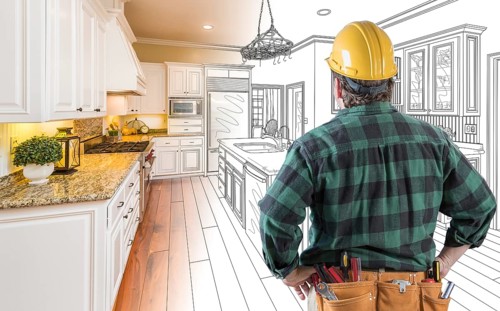 Male contractor with hard hat and tool belt looking at custom kitchen drawing photo combination on white