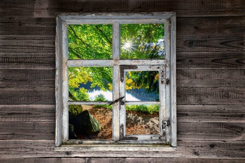 View through a rustic wooden window onto the Feldsee
