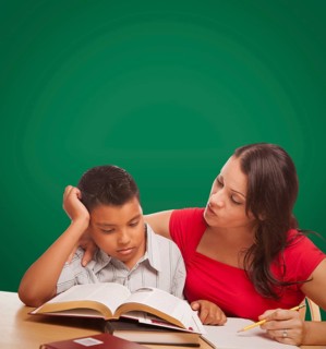 Blank chalk board behind hispanic young boy and famale adult studying