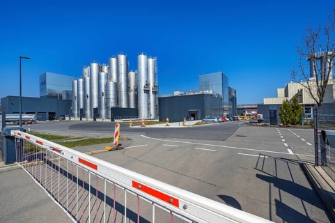 Schranke vor Fabrik mit Hochsilos
