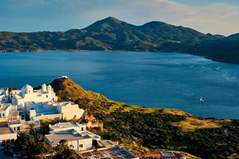 View of Plaka village on Milos island with traditional greek white houses on sunset