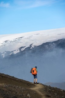 Hikers on trail through volcanic landscape