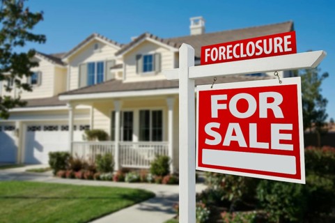 Foreclosure home for sale real estate sign in front of new house