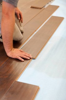 Man installing new laminate wood flooring abstract