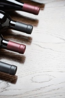 Various wine bottles on a reflective wood surface abstract
