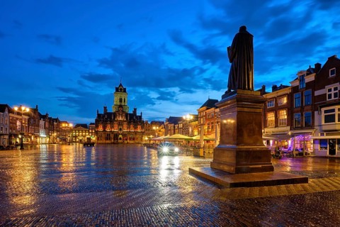 Delft City Hall and Delft Market Square Markt with Hugo de Groot Monument in the evening