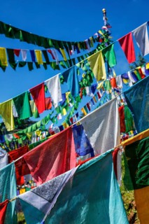 Buddhist prayer flags lungta with Om Mani Padme Hum Buddhist mantra prayer meaning Praise to the Jewel in the Lotus on kora around Tsuglagkhang complex