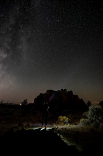 Young woman on a path shines torch