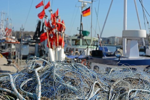 Fischernetze und Fischerfaehnchen im Fischereihafen Travemuende