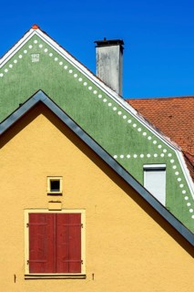 Orange Fassade und Dach mit Bieberschwanzziegeln