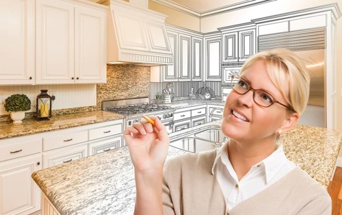 Creative woman with pencil over custom kitchen design drawing and photo combination
