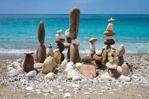 Concept of balance and harmony. Stones pebbles stacks on the beach coast of the blue sea in the nature. Meditative art of stone stacking