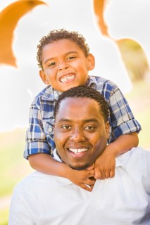 Happy african american father and mixed-race son playing at the park