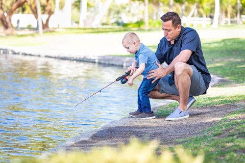 Young caucasian father and son having fun fishing at the lake